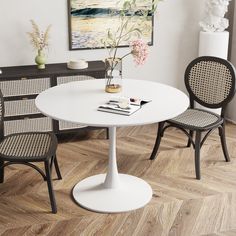 a white table with two chairs and a vase on it in front of a painting