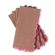 four brown napkins with pink scalloped edges