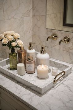 a bathroom sink with candles and flowers on it