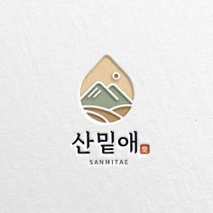 the korean language logo for sanmita is shown on a white surface with mountains in the background