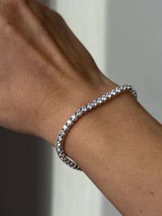 Bask in the luminous brilliance of this exquisite Tennis Bracelet. Crafted with 925 Sterling Silver, this timeless piece is set with 6.00TCW of round-cut created diamonds, delivering a sparkle that is sure to turn heads. Ensuring maximum comfort and security, its 3mm band is exquisitely designed for an effortless fit. This exquisite bracelet finished in high polished rhodium that gives it a stunning shiny look that lasts for many years. Our created diamonds and gemstones are synthetic simulants Sterling Silver Tennis Bracelet With Brilliant Cut, Dazzling Round Sterling Silver Diamond Bracelet, Dazzling Sterling Silver Tennis Bracelet For Anniversary, White Sterling Silver Tennis Bracelet For Anniversary, Classic Round Band Bracelet For Anniversary, Classic Silver Tennis Bracelet With Prong Setting, Dazzling Sterling Silver Jubilee Bracelet For Anniversary, Classic White Sterling Silver Bracelet With Diamond Accents, Silver Diamond Cut Tennis Bracelet For Anniversary