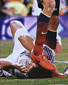 a soccer player is laying on the ground with his foot in the air as he falls