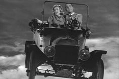 two people in an old car flying through the air