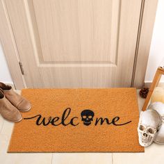 a welcome mat with a skull on it and shoes next to the doormat that says welcome