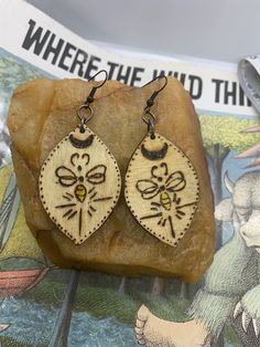 the earrings are made out of wood and have bees on them