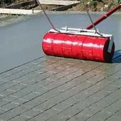 a red barrel laying on top of a brick road