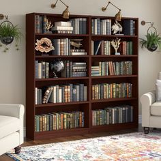 a living room filled with lots of books on top of a wooden book shelf next to a white couch