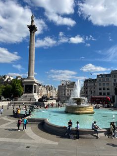 people are standing around in front of a fountain