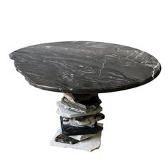 a black marble table sitting on top of a pile of books