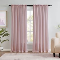 a living room with pink curtains and a chair