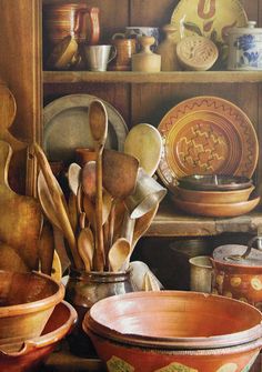 there are many bowls and spoons on the shelf