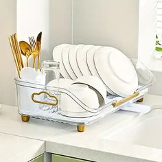 there is a dish rack with plates and utensils in it on the counter