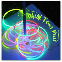 glowing neon rings are on the ground in front of a sign that says ring toss