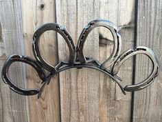 a pair of scissors hanging on a wooden fence