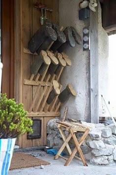 a bunch of shoes that are hanging up on the side of a building and some chairs