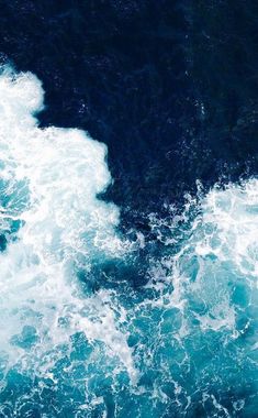 an aerial view of the ocean waves and foamy blue water, taken from above