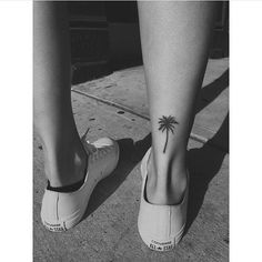 a woman's foot with a small palm tree tattoo on her left calf and the bottom part of her leg