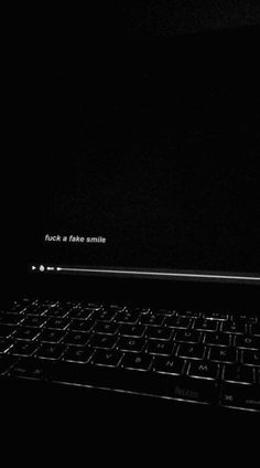 a laptop computer sitting on top of a black surface with the words flickr and fake smile written on it