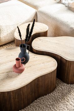 two wooden tables with vases sitting on top of each other in a living room