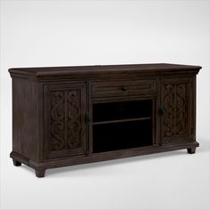 a wooden entertainment center with an ornate design on the front and bottom panel, in dark brown