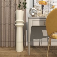 a white vase sitting on top of a wooden floor next to a desk and chair