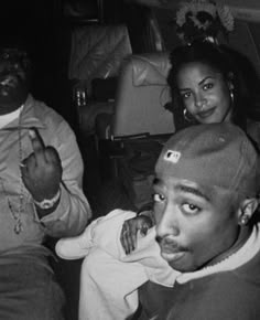 three young people sitting on the floor in front of a couch and one is holding something up to his mouth