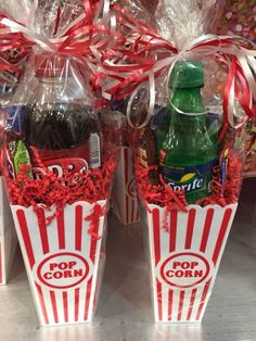 two red and white popcorn buckets with pop corn in them