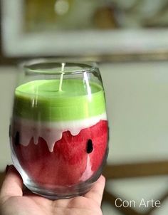 a hand holding a wine glass filled with watermelon