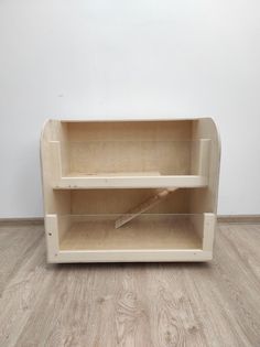 a wooden shelf sitting on top of a hard wood floor next to a white wall