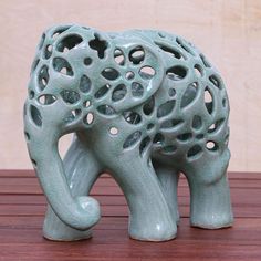 an elephant figurine sitting on top of a wooden table