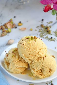 three scoops of vanilla ice cream on a white plate with flowers in the background