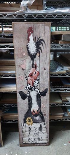 a wooden sign with an image of a cow and rooster on it's head