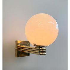 a light that is on the side of a wall next to a metal object with a glass ball on it