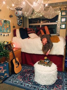 a man laying on top of a bed in a room with lots of lights hanging from the ceiling