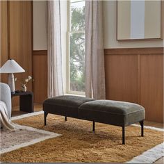 a living room scene with focus on the footstool and carpeted flooring