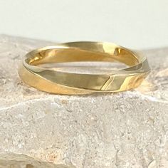 a close up of a gold ring on a rock