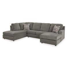 a gray sectional couch with pillows on the top and bottom corner, in front of a white background