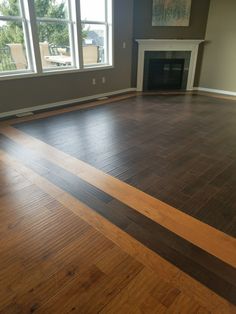 an empty living room with hard wood floors and large windows in the backround