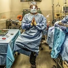 two doctors in scrubs and protective gear standing next to each other with surgical equipment around them