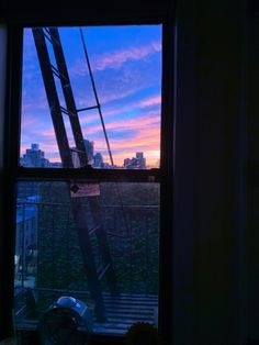 a window with a view of the city at sunset