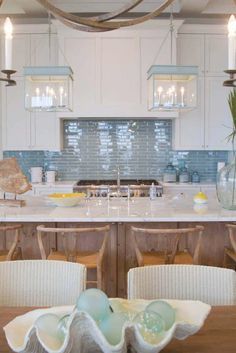 a large kitchen with an island in the middle and two chairs at the table on one side