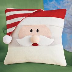 a pillow with a santa claus face on it's side and a green chair in the background