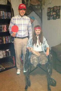 a man standing next to a woman in a wheel chair with a paddle on it