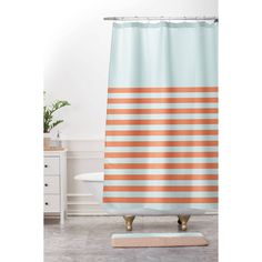 a shower curtain with an orange and white stripe pattern on it, in a bathroom