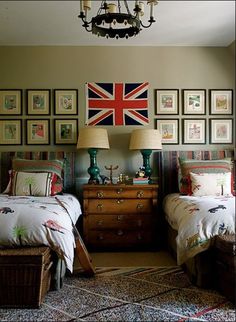 two twin beds in a bedroom with pictures on the wall above them and a chandelier