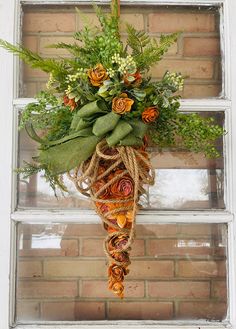 a bouquet of flowers hanging from the side of a window