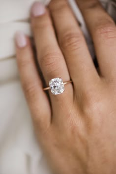 a woman's hand with a diamond ring on it