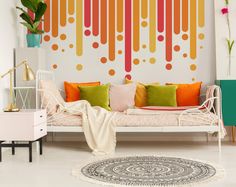 a living room with a white couch and colorful wallpaper on the walls behind it