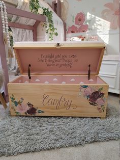 an empty wooden box with flowers painted on the inside and writing that says, happily