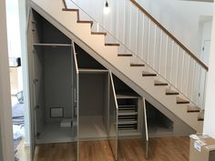 an open closet under the stairs in a house